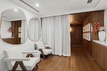A modern living room with white furniture and wooden accents.